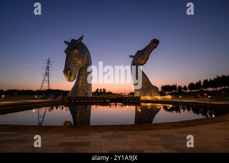 Berühmte schottische Touristenattraktion, die Kelpies, reflektieren im Wasser im Helix, Grangemouth, Falkirk, Schottland, Großbritannien bei Sonnenuntergang Stockfoto