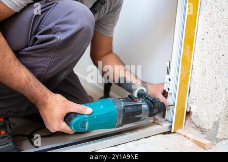 Professionelle Zimmerleute installieren eine Eingangstür in einer neuen Wohnung. Der Türmonteur hat den alten durch einen neuen ersetzt Stockfoto