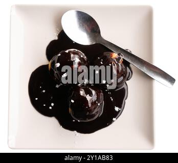 Traditionelles französisches Dessert, Creme Profiteroles mit Schokoladenglasur auf Teller Stockfoto