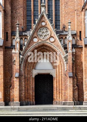 Haupteingang der Kirche aus rotem Backstein im neogotischen Stil. Stockfoto