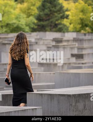 Frau, die das Holocaust-Denkmal, Gedenkstätte für die ermordeten Juden Europas, in Berlin, Deutschland, ansieht Stockfoto