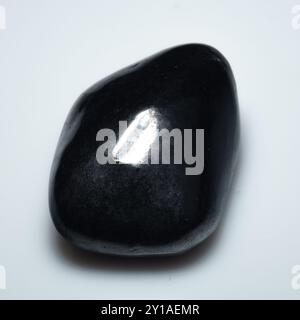 Eleganter polierter Shungit-Edelstein auf makellosem weißem Hintergrund. Stockfoto