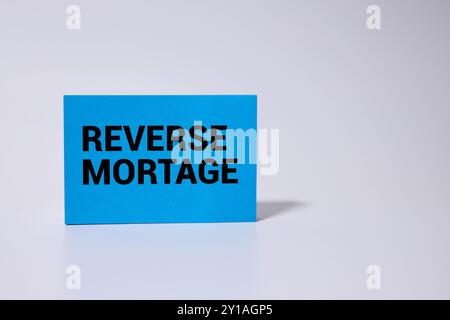 Reverse Mortage Textnachricht mit Hausmodell und Zakulator auf Holzhintergrund Stockfoto