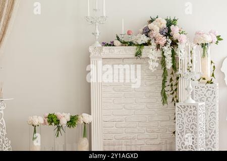 Elegantes Blumendesign im Vintage-Stil mit weißem Kamin. Stockfoto