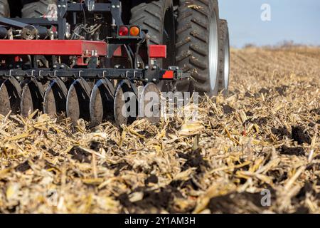 Traktor zieht Meißel Pflügen Anbaugerät auf dem Feld des landwirtschaftlichen Betriebs. Bodenbearbeitung, Erosionskontrolle und Bodenverdichtung. Stockfoto