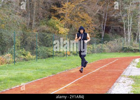 Junger Mann morgens joggen im Freien auf der Rennstrecke Stockfoto