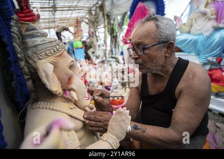 Ein Handwerker gibt einem Idol der Elefantenköpfigen hinduistischen Gottheit Ganesha bei einem Workshop vor dem Ganesh Chaturthi Festival im September letzten Schliff Stockfoto