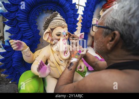 Ein Handwerker gibt einem Idol der Elefantenköpfigen hinduistischen Gottheit Ganesha bei einem Workshop vor dem Ganesh Chaturthi Festival im September letzten Schliff Stockfoto