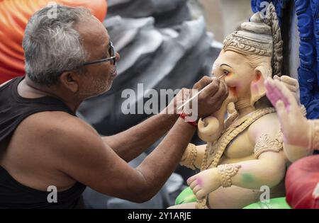 Ein Handwerker gibt einem Idol der Elefantenköpfigen hinduistischen Gottheit Ganesha bei einem Workshop vor dem Ganesh Chaturthi Festival im September letzten Schliff Stockfoto