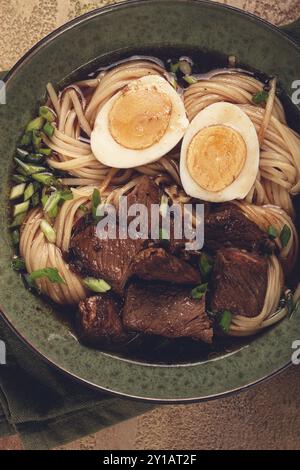 Asiatische Nudeln in Brühe, mit Rindfleisch und Ei, Blick von oben, Nahaufnahme, keine Leute Stockfoto