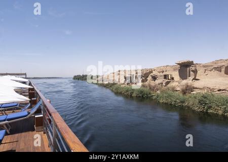 Bestaunen Sie die Mystik der antiken Ruinen am Ufer des Nils, die vom Deck eines luxuriösen Kreuzfahrtschiffs erfasst wurden. Ideal für Geschichtsinteressierte und Reisereisende Stockfoto