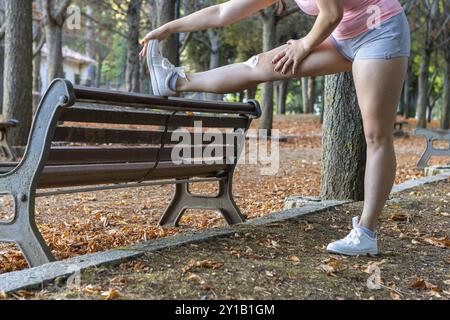 Attraktive sportliche Frau, die sich im Park aufhält. Schönes Mädchen, das Aufwärmübungen in einem Park macht Stockfoto