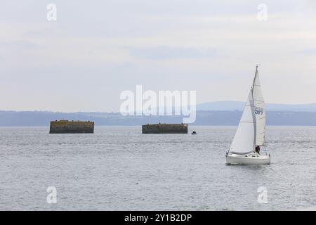 Segelboot vor den beiden Delfinen, die die deutsche Marine während des Zweiten Weltkriegs in der Bucht Rade de Brest vor dem Plougastel-Daoulas gebaut hat Stockfoto