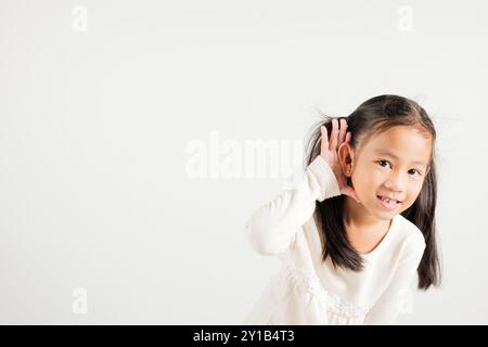 Portrait Asiatisches kleines Kind lächelnd hörend hörend Tratsch mit Aufmerksamkeit mit der Hand Stockfoto