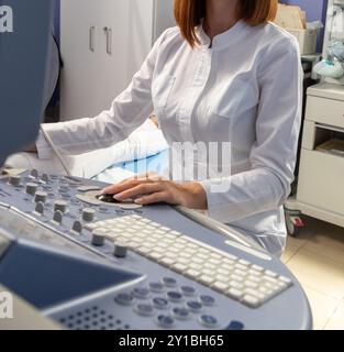 Der Arzt führt eine Ultraschalldiagnostik der Bauchhöhle eines schwangeren Mädchens in einem frühen Stadium der Schwangerschaft durch. Ultraschall-Untersuchung von Intestin Stockfoto