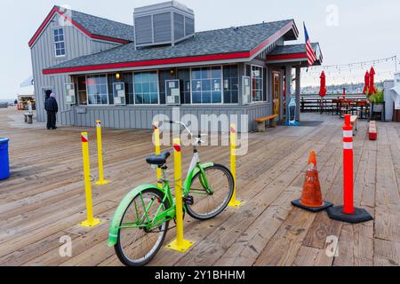 Santa Barbara, Kalifornien - 20. April 2024: Fahrrad parkt in der Nähe eines Restaurants an der Küste mit farbenfrohen Barrieren und Kegeln, die Santa Barbaras Vibr zeigen Stockfoto