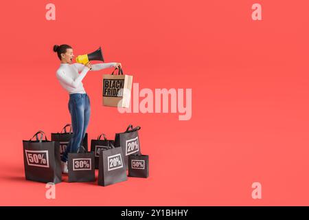 Die Frau ruft in ein Megaphon, umgeben von Einkaufstaschen auf rotem Hintergrund, und kündigt schwarze freitagsgeschäfte an. 3D-Rendering Stockfoto