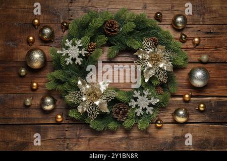 Weihnachtskranz mit Kegeln, Kugeln und dekorativen Schneeflocken auf Holztisch, flach gelegt Stockfoto