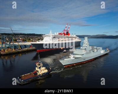 Greenock, Schottland, Großbritannien. September 2024. Aus der Vogelperspektive der HMS Cardiff Typ 26 Fregatte, die am Kreuzfahrtschiff Queen Mary 2 in Greenock vorbeisegelt, auf dem Weg von Glenmallan zur BAE Werft am Fluss Clyde in Scotstoun in Glasgow. Die Fregatte wurde mit einem Lastkahn nach Glenmallan gebracht, um in tiefem Wasser zu starten, und wird nun in der Scotstoun Werft ausgerüstet. Bild: Iain Masterton/Alamy Live News Stockfoto