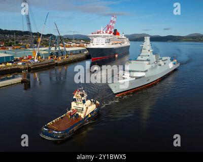 Greenock, Schottland, Großbritannien. September 2024. Aus der Vogelperspektive der HMS Cardiff Typ 26 Fregatte, die am Kreuzfahrtschiff Queen Mary 2 in Greenock vorbeisegelt, auf dem Weg von Glenmallan zur BAE Werft am Fluss Clyde in Scotstoun in Glasgow. Die Fregatte wurde mit einem Lastkahn nach Glenmallan gebracht, um in tiefem Wasser zu starten, und wird nun in der Scotstoun Werft ausgerüstet. Bild: Iain Masterton/Alamy Live News Stockfoto