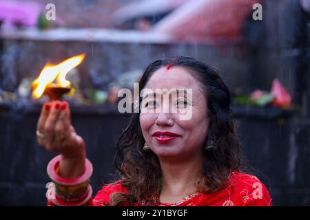 Eine fastende nepalesische Hindu-Frau bietet eine Butterlampe an, während sie am 6. September 2024 Rituale im Pashupatinath-Tempel in Kathmandu, Nepal, ausführt, um das fest von Teej zu feiern. Nach der Tradition beobachten Frauen an diesem dritten Tag der dunklen Hälfte des Mondmonats, der in den nepalesischen Monat Bhadra fällt, Fasten und wünschen sich ein wohlhabendes Leben während der Beobachtung des Festivals. Nach der Skanda Puran (eine religiöse Schrift der Hindus), erhält dieses Festival den Namen Haritalika Teej, wie es an diesem Tag in der Satya Yug (goldene Epoche der Wahrheit) ist, dass die Tochter des Himalaya, Stockfoto