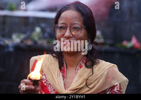 Eine fastende nepalesische Hindu-Frau bietet eine Butterlampe an, während sie am 6. September 2024 Rituale im Pashupatinath-Tempel in Kathmandu, Nepal, ausführt, um das fest von Teej zu feiern. Nach der Tradition beobachten Frauen an diesem dritten Tag der dunklen Hälfte des Mondmonats, der in den nepalesischen Monat Bhadra fällt, Fasten und wünschen sich ein wohlhabendes Leben während der Beobachtung des Festivals. Nach der Skanda Puran (eine religiöse Schrift der Hindus), erhält dieses Festival den Namen Haritalika Teej, wie es an diesem Tag in der Satya Yug (goldene Epoche der Wahrheit) ist, dass die Tochter des Himalaya, Stockfoto