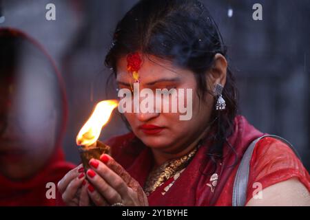 Eine fastende nepalesische Hindu-Frau bietet eine Butterlampe an, während sie am 6. September 2024 Rituale im Pashupatinath-Tempel in Kathmandu, Nepal, ausführt, um das fest von Teej zu feiern. Nach der Tradition beobachten Frauen an diesem dritten Tag der dunklen Hälfte des Mondmonats, der in den nepalesischen Monat Bhadra fällt, Fasten und wünschen sich ein wohlhabendes Leben während der Beobachtung des Festivals. Nach der Skanda Puran (eine religiöse Schrift der Hindus), erhält dieses Festival den Namen Haritalika Teej, wie es an diesem Tag in der Satya Yug (goldene Epoche der Wahrheit) ist, dass die Tochter des Himalaya, Stockfoto