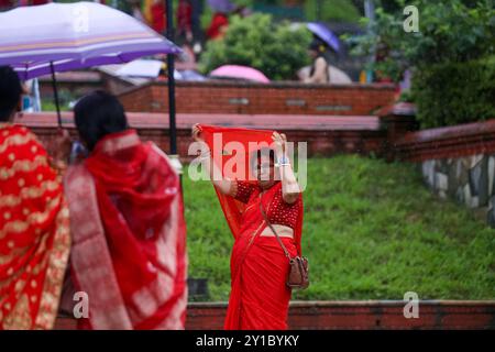 Eine fastende nepalesische Hindu-Frau, die sich in rot gekleidet hat, posiert für ein Foto im Pashupatinath-Tempel in Kathmandu, Nepal, am 6. September 2024, anlässlich des Teej-Festes. Der Tradition nach beobachten Frauen an diesem dritten Tag der dunklen Hälfte des Mondmonats, der in den nepalesischen Monat Bhadra fällt, Fasten und wünschen sich ein wohlhabendes Leben während der Feier des Festivals. Laut der „Skanda Puran“ (eine religiöse Schrift der Hindus) wird dieses Festival „Haritalika Teej“ genannt, weil an diesem Tag in der „Satya Yug“ (goldene Epoche der Wahrheit) die Tochter des Himalaya, Parvati, von ihrem mai versteckt wird Stockfoto