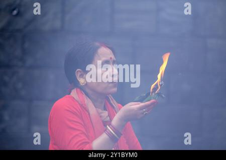 Eine fastende nepalesische Hindu-Frau bietet eine mit Öl gefüllte Lampe an, während sie Rituale im Pashupatinath Tempel in Kathmandu, Nepal, am 6. September 2024, anlässlich des Festes von Teej, vorführt. Nach der Tradition beobachten Frauen an diesem dritten Tag der dunklen Hälfte des Mondmonats, der in den nepalesischen Monat Bhadra fällt, Fasten und wünschen sich ein wohlhabendes Leben während der Beobachtung des Festivals. Laut der „Skanda Puran“ (eine religiöse Schrift der Hindus) erhält dieses Festival den Namen „Haritalika Teej“, da es an diesem Tag in der „Satya Yug“ (goldene Epoche der Wahrheit) die Tochter des Himalaya, Pa ist Stockfoto