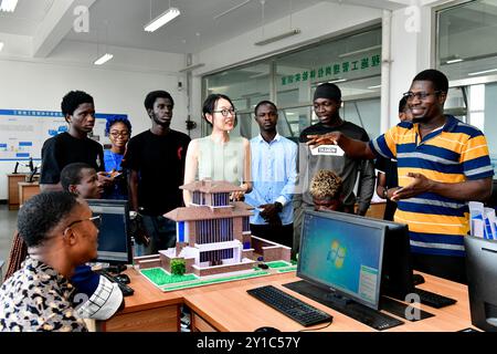 (240906) -- JINAN, 6. September 2024 (Xinhua) -- Xi Xiaomeng (4. R), ein Lehrer der Abteilung für Architekturtechnik, spricht mit ghanaischen Studenten während der Pause am Rizhao Polytechnic in Rizhao, ostchinesischer Provinz Shandong, 5. September 2024. Rizhao Polytechnic, das 2021 mit der Technischen Universität Kumasi eine Zusammenarbeit im Bereich der beruflichen Bildung aufnahm, hat durch Lehrerausbildung und Berufsausbildung sowie durch kulturellen und pädagogischen Austausch dazu beigetragen, berufliche Talente in Ghana zu fördern. Derzeit haben 42 ghanaische Studenten in der Polytechnik Rizhao studiert und erhalten p Stockfoto