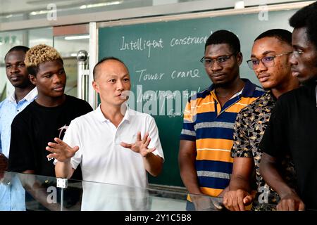 (240906) -- JINAN, 6. September 2024 (Xinhua) -- Ma Fangxing (3. L), ein Lehrer der Abteilung für Architekturtechnik, spricht mit ghanaischen Studenten vor einem Sandtisch am Rizhao Polytechnic in Rizhao, ostchinesischer Provinz Shandong, 5. September 2024. Rizhao Polytechnic, das 2021 mit der Technischen Universität Kumasi eine Zusammenarbeit im Bereich der beruflichen Bildung aufnahm, hat durch Lehrerausbildung und Berufsausbildung sowie durch kulturellen und pädagogischen Austausch dazu beigetragen, berufliche Talente in Ghana zu fördern. Derzeit haben 42 ghanaische Studenten in Rizhao Polytechnic und REC studiert Stockfoto