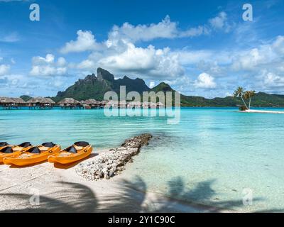 Blick auf den Mount Otemanu durch türkisfarbene Lagune, Palmen und Überwasser-Bungalows auf Bora Bora Island, Tahiti, Französisch-Polynesien und Südpazifik Stockfoto