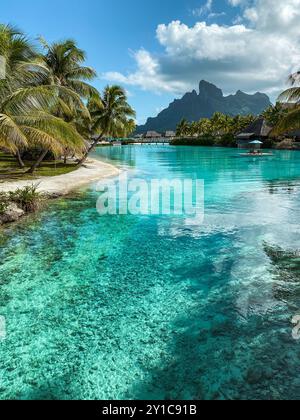 Blick auf den Mount Otemanu durch türkisfarbene Lagune, Palmen und Überwasser-Bungalows auf Bora Bora Island, Tahiti, Französisch-Polynesien und Südpazifik Stockfoto