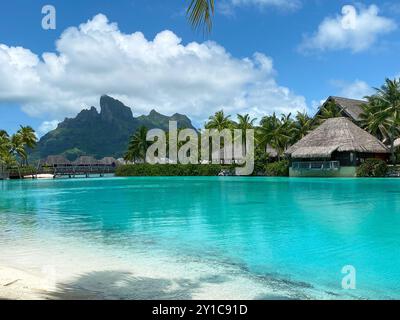 Blick auf den Mount Otemanu durch türkisfarbene Lagune, Palmen und Überwasser-Bungalows auf Bora Bora Island, Tahiti, Französisch-Polynesien und Südpazifik Stockfoto