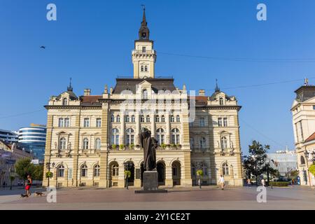 Die Außenfassade des Rathauses von Novi Sad in Serbien auf dem Freiheitsplatz, mit der Statue von Svetozar Miletic an einem sonnigen Tag mit blauem wolkenlosem Himmel. Stockfoto