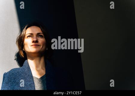 Entspannte junge Frau, die einen sonnigen Tag in der Stadt genießt Stockfoto