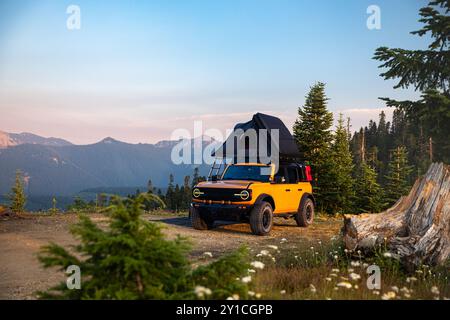 Gelber Überlandwagen, der auf einer Klippe in der Nähe des Mt. Rainier, Washington Stockfoto