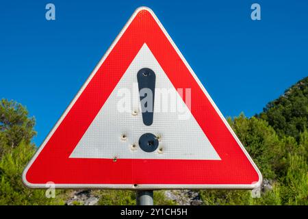 Dreieckiges Verkehrszeichen mit Ausrufezeichen und Einschusslöchern. Montenegro Stockfoto