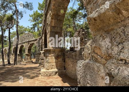 Detaillierte archäologische Ruinen des antiken römischen Aquädukts in Türkiye, Aphrodisias, Steinwasserbrücke, zweistöckige Mauer zwischen grünen Bäumen, Natur und Dörfern Stockfoto