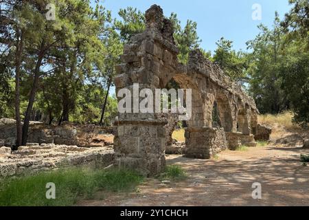 Detaillierte archäologische Ruinen des antiken römischen Aquädukts in Türkiye, Aphrodisias, Steinwasserbrücke, zweistöckige Mauer zwischen grünen Bäumen, Natur und Dörfern Stockfoto