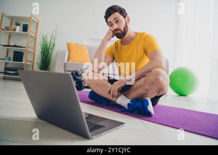 Foto von attraktiven athletischen starken Mann hören Video-Übungen Indoor House Home Gym Stockfoto