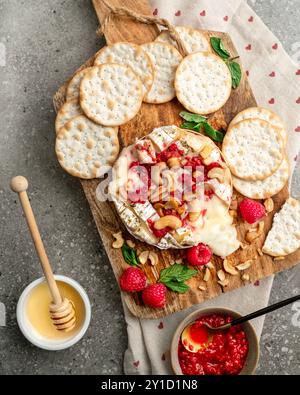 Gebackener Camembert-Käse, serviert mit Preiselbeeren und Cashewnüssen, mit Honig getränkt Stockfoto