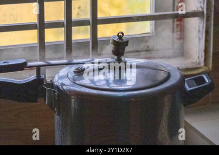 Dampf austritt aus dem Deckel des Druckkochers in der Küche. Druckkochgeräte sind luftdichte Kochgeräte, die Dampf und Druck zum Kochen von Speisen verwenden q Stockfoto