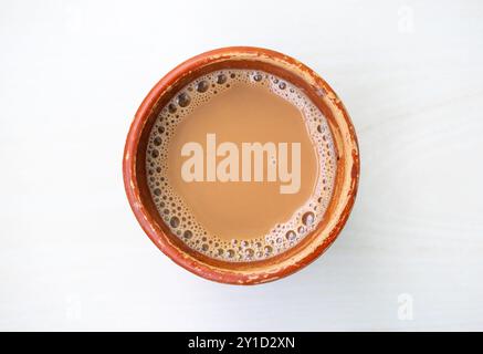 Eine Tasse Milchtee oder Dudh Cha in einer traditionellen Tasse aus natürlichem Ton. Draufsicht Stockfoto