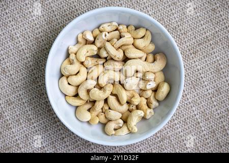 Leckere Cashewnüsse in einer weißen Schüssel auf einem schönen strukturierten Hintergrund. Sein wissenschaftlicher Name ist Anacardium occidentale und in der bengalischen Sprache Stockfoto