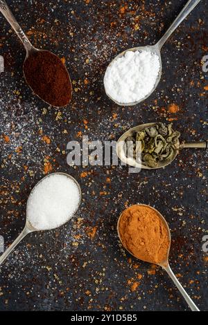 Löffel mit Puderzucker, Kaffee und Kakao auf schwarzem Hintergrund bestreut mit braunem und weißem Zucker, Kaffee, Kakaopulver. Stockfoto