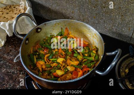 Heiße, dampfende Okra gemischt mit Gemüse, Kräutern und Gewürzen, die in einer indischen Küche gekocht werden. Perfekt für indische Küche und Footage. Stockfoto