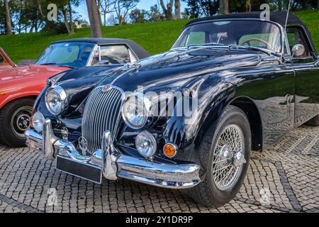 Lissabon, Portugal - 20. Januar 2024: Vintage-dunkelgrüner Jaguar XK150 Coupé mit Klappkopf auf Kopfsteinpflasterstraße parkt. Zweisitziger Roadster, Sportwagen, Cabriolet Stockfoto