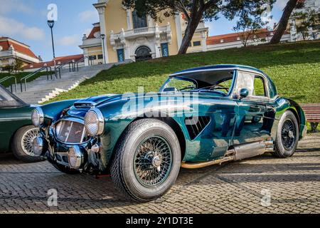 Lissabon, Portugal - 20. Januar 2024: Der grüne Vintage-Sportwagen Austin Healey 3000 auf Kopfsteinpflaster in der Nähe des grünen Parks. 2-türiger 2-Sitzer Roadster mit Hardtop von Austin-Healey BMC Stockfoto