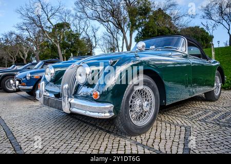 Lissabon, Portugal – 20. Januar 2024: Klassischer, dunkelgrüner Jaguar XK150 Coupé mit Klappkopf auf Kopfsteinpflasterstraße parkt. Zweisitziger Roadster, Sportwagen, Cabriolet Stockfoto
